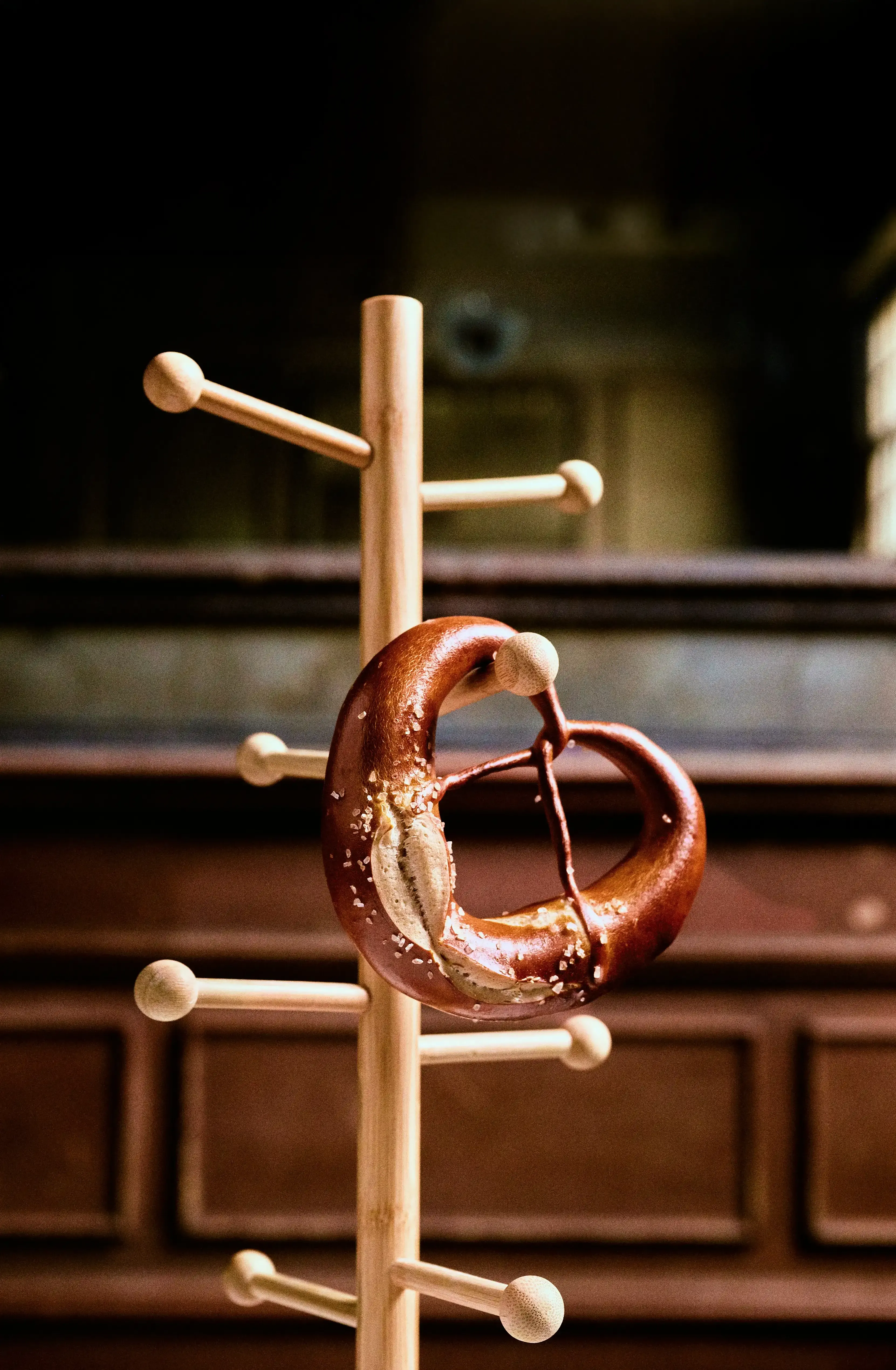 Detail shot of a Pretzel hanging from a wooden stand